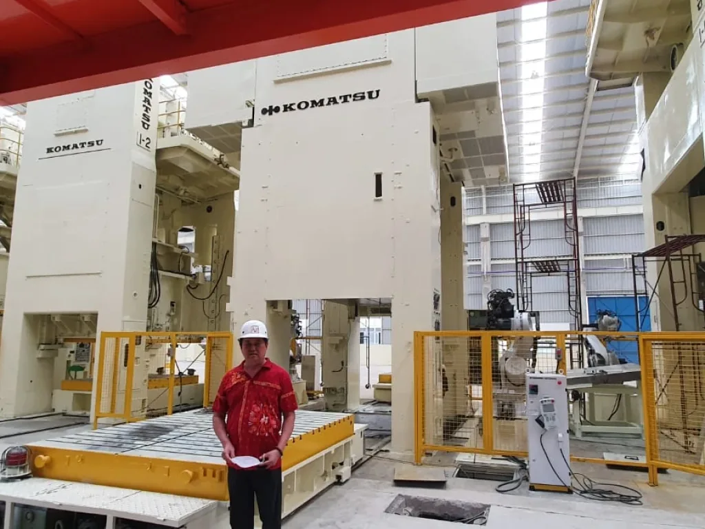 Engineer in a hard hat beside presses being installed, with the bolster drawn out