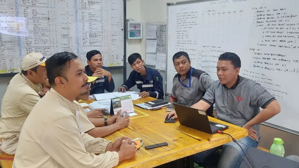 Engineers and production staff reviewing work at a table on the shop floor